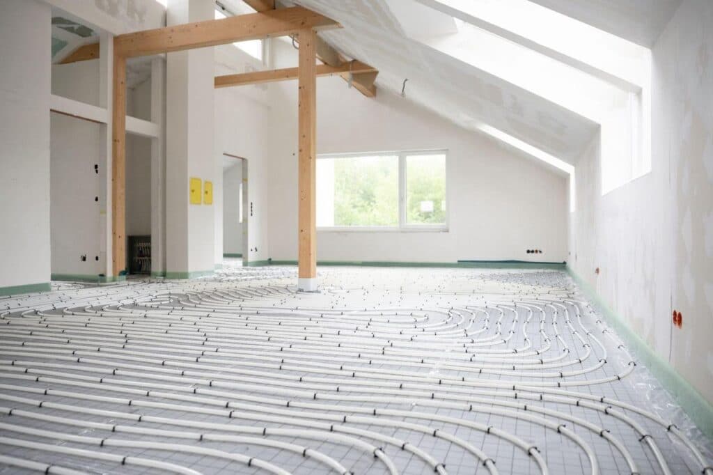A room featuring visible heating pipes and a central heating system installed on the wall