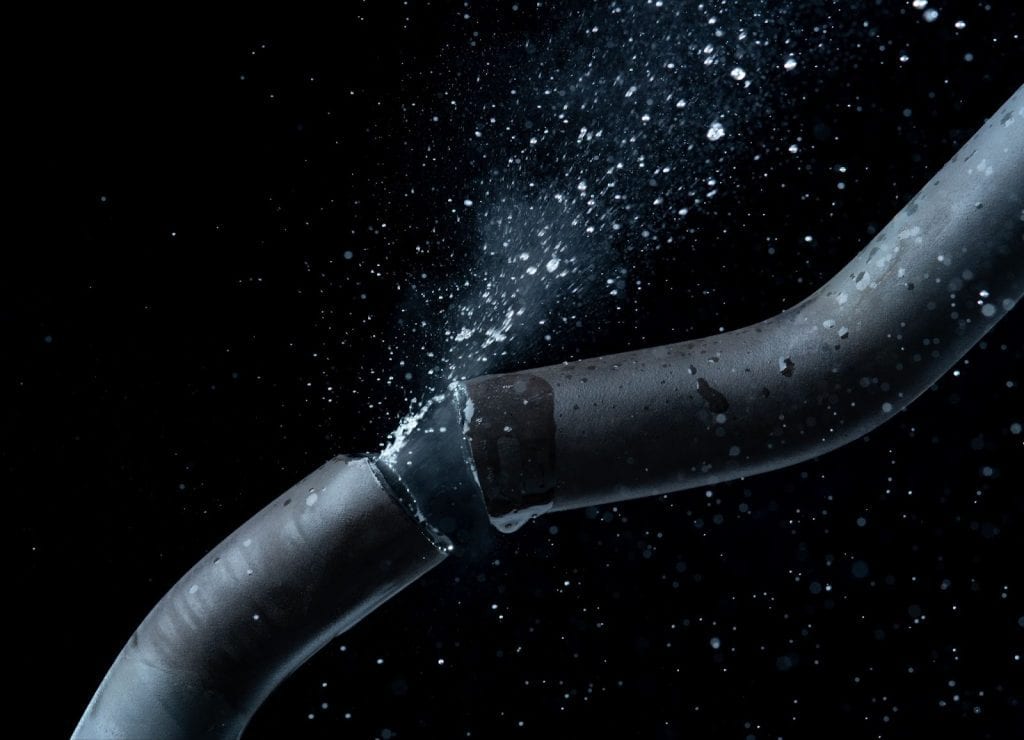 A burst water pipe with water gushing out, part of a plumbing system