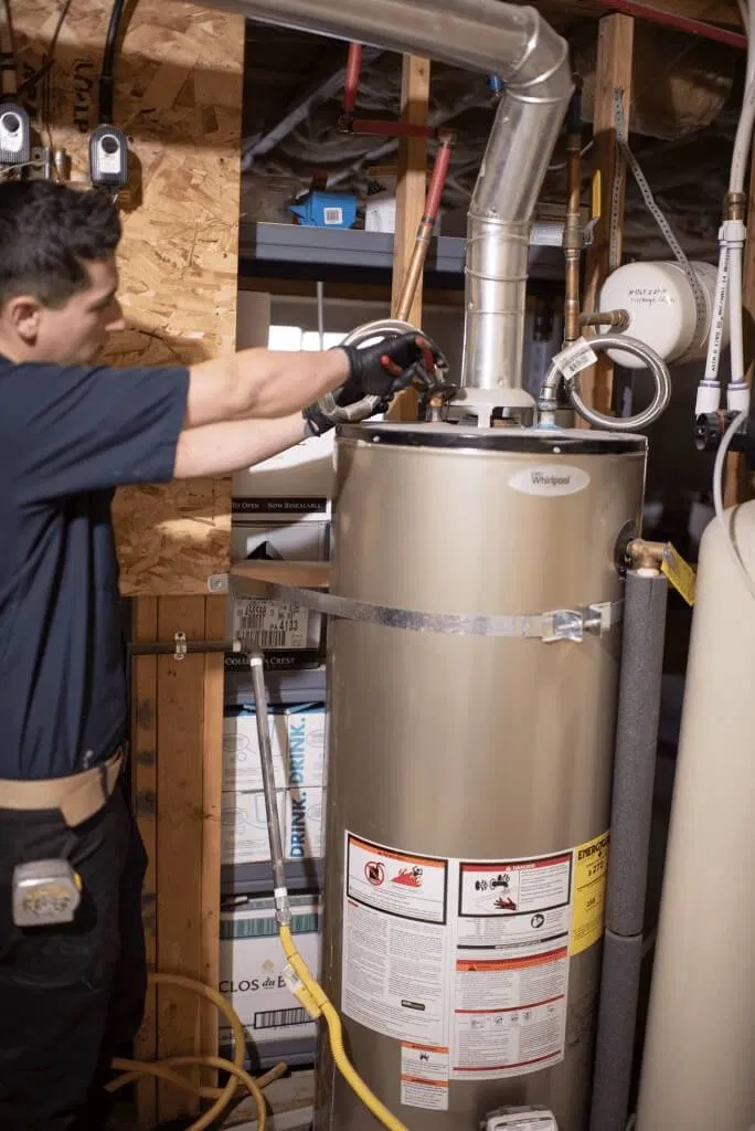 A plumber fixing a leaky pipe in a bathroom.