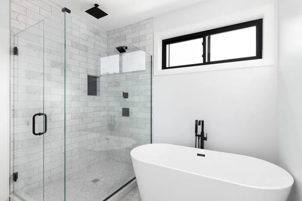 Bathroom with white tub and glass shower door.