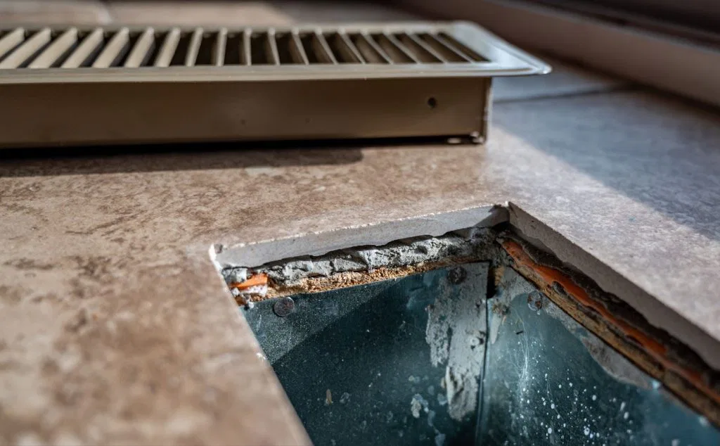 Metal grate with hole, used in radiant heating system for efficient heat distribution