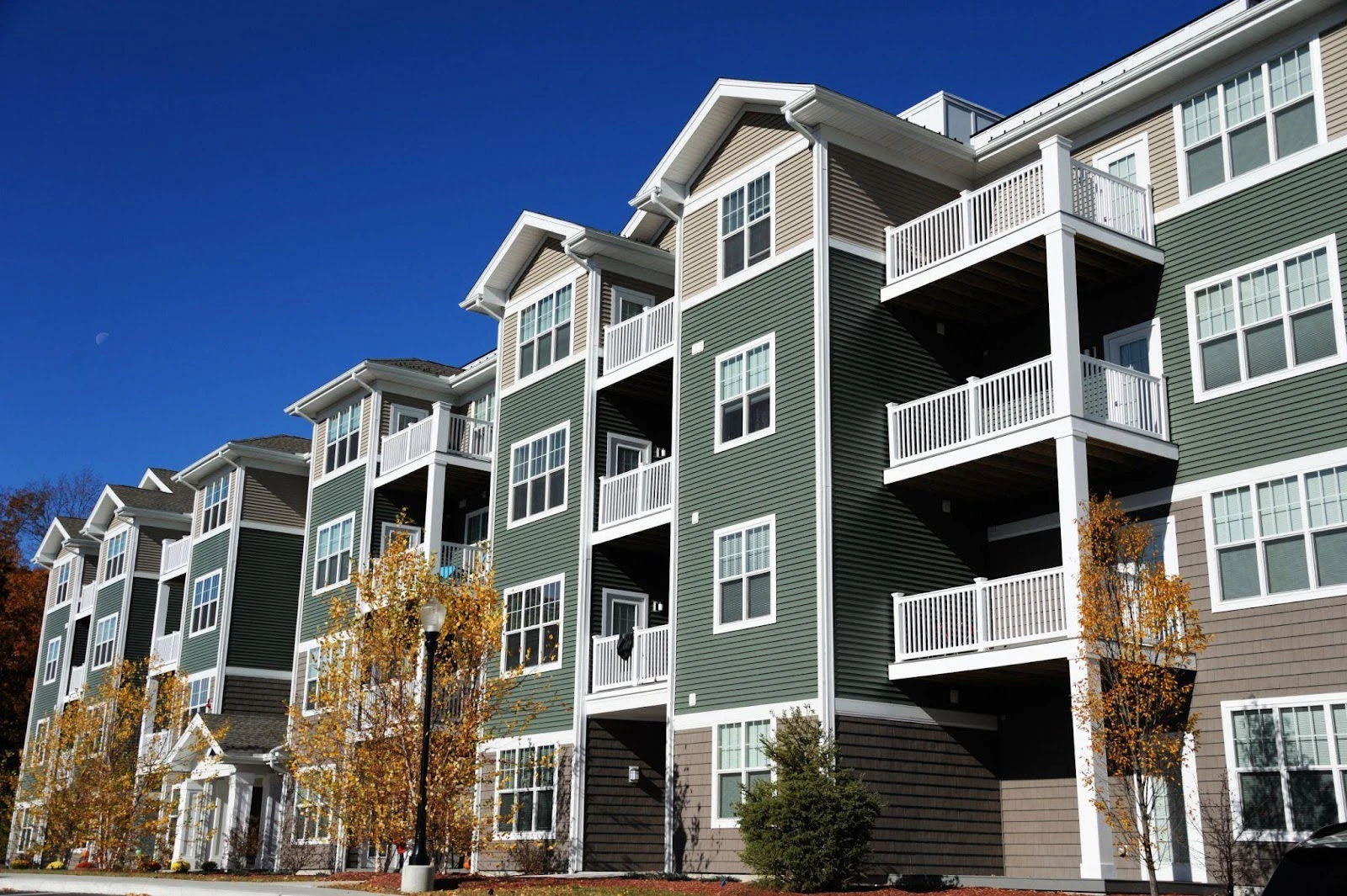 Exterior view of an apartment building featuring green and gray siding