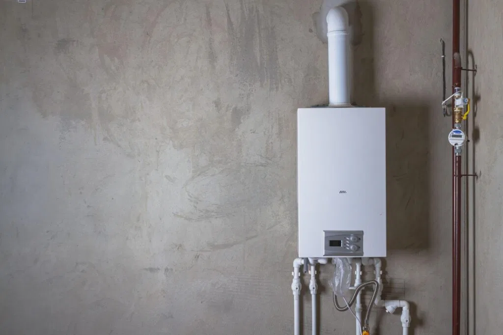 A gas boiler installed in a room surrounded by various pipes connected to the heating system