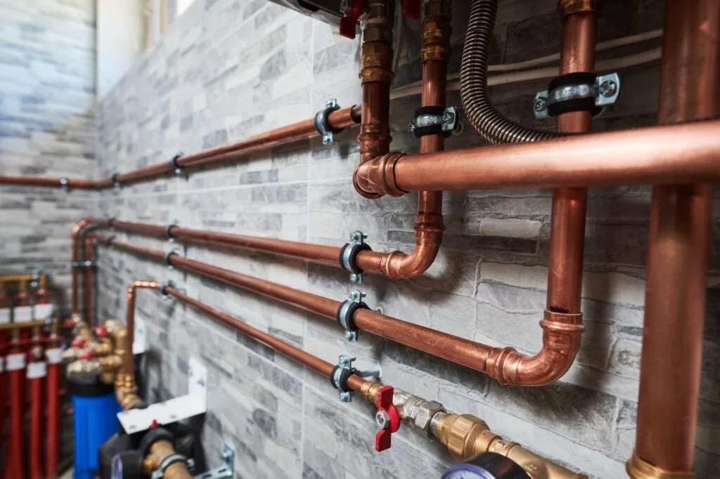 Detailed view of copper pipes and valves highlighting their texture and arrangement in a plumbing system