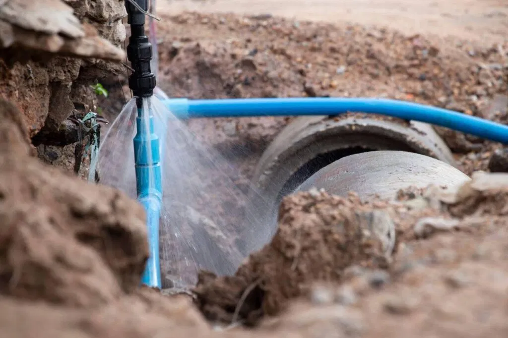 A blue pipe is actively cleaning another pipe showcasing a maintenance process in progress